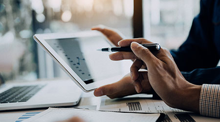 Hand pointing to a tablet