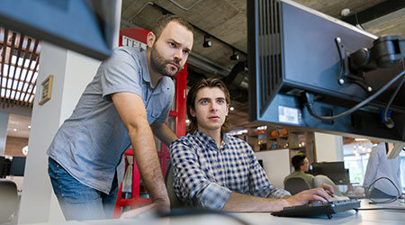 Men working looking at a screen
