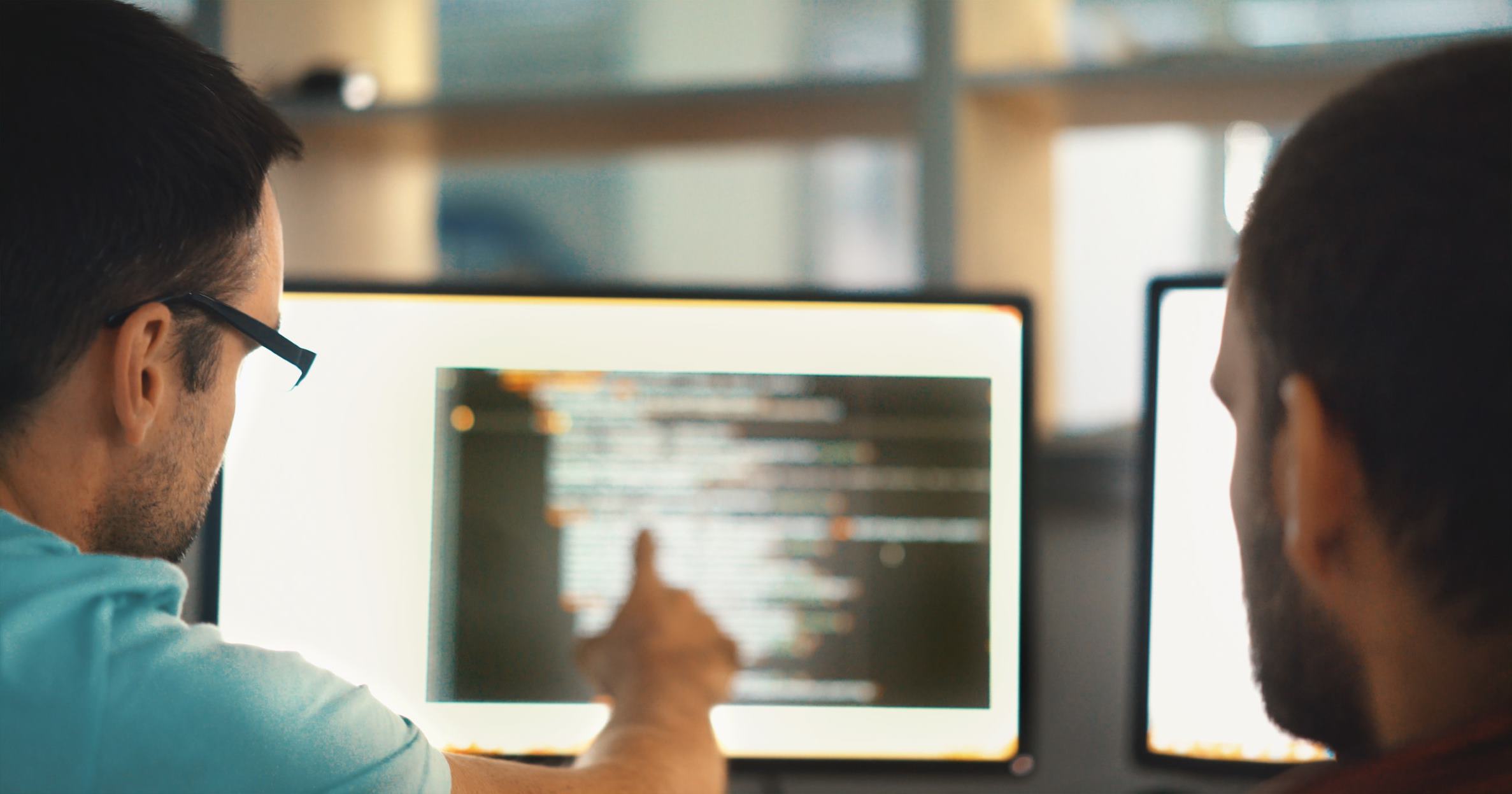 person pointing at the codes on the computer
